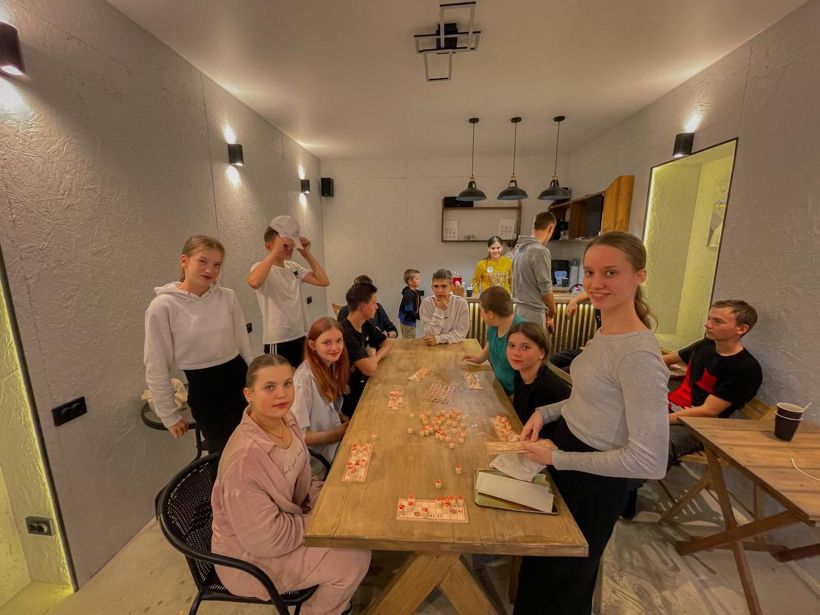 Підлітки грають у настільну гру за столом